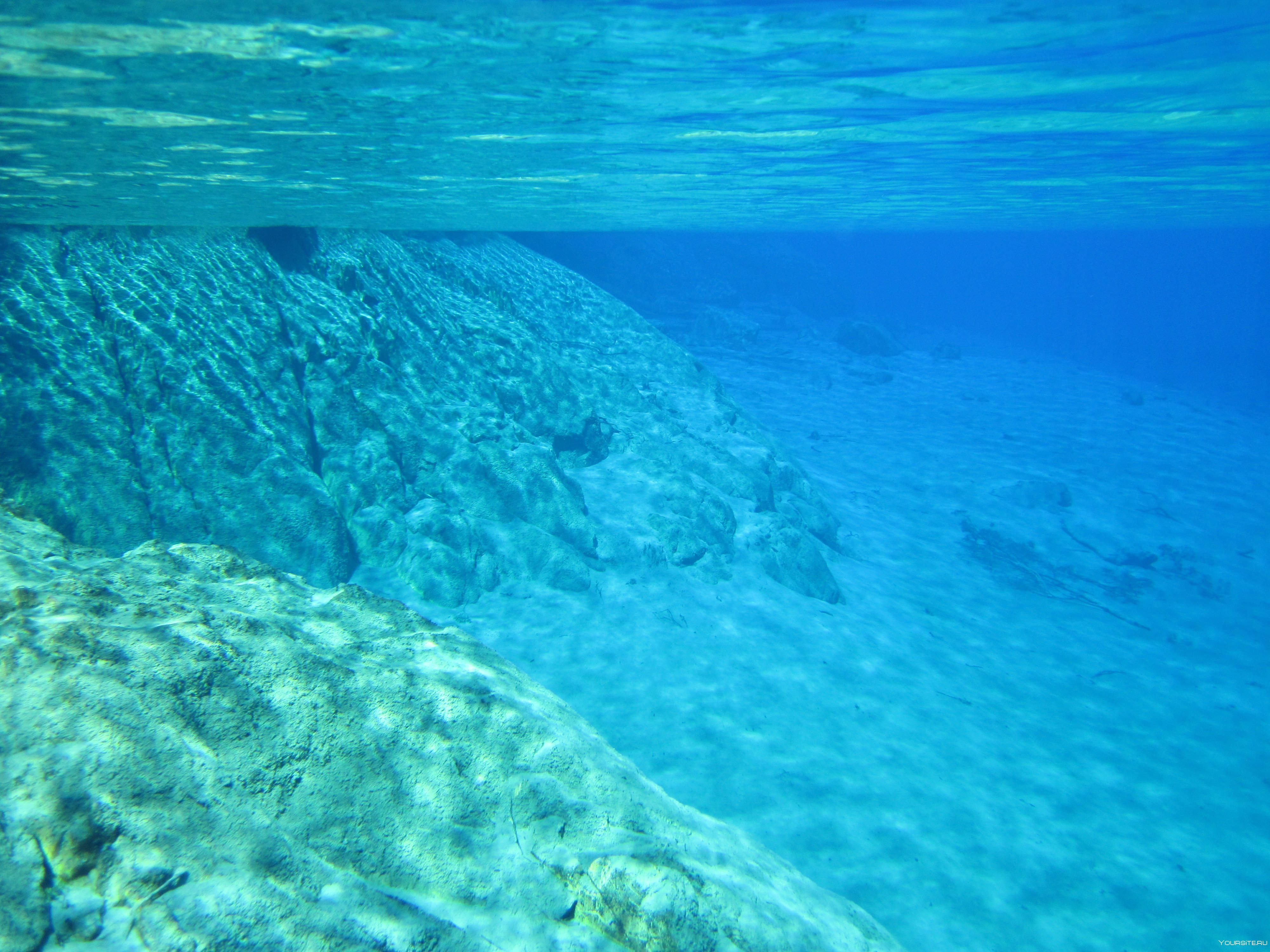 Поверхность воды тихого океана. Голубое озеро (Rotomairewhenua). Дно океана. Прозрачное море. Прозрачная вода море.