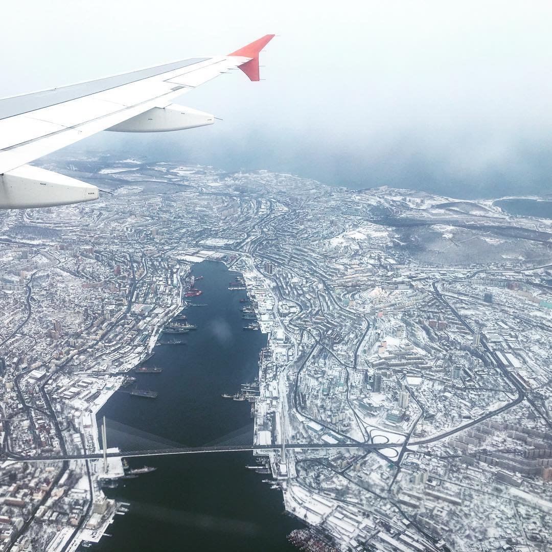 Самолет москва калифорния. Вид с самолета зимой. Владивосток вид из самолета. Вид с самолета ночью Владивосток. Вид из окна самолета зимой.